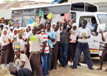 Students from Buyani High School posing with the TRLF bus which transports the books to the school 